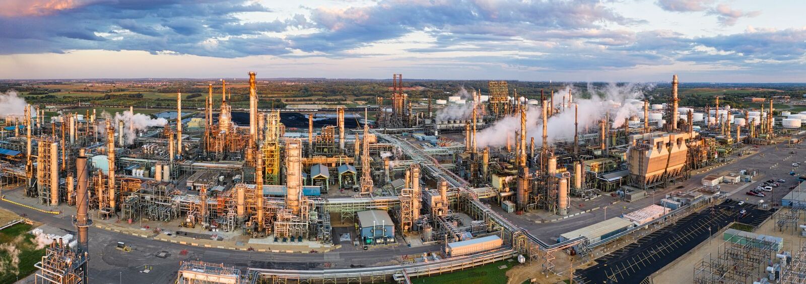 Aerial panorama of a sprawling oil refinery in Rosemount, Minnesota, with industrial structures and emissions.
